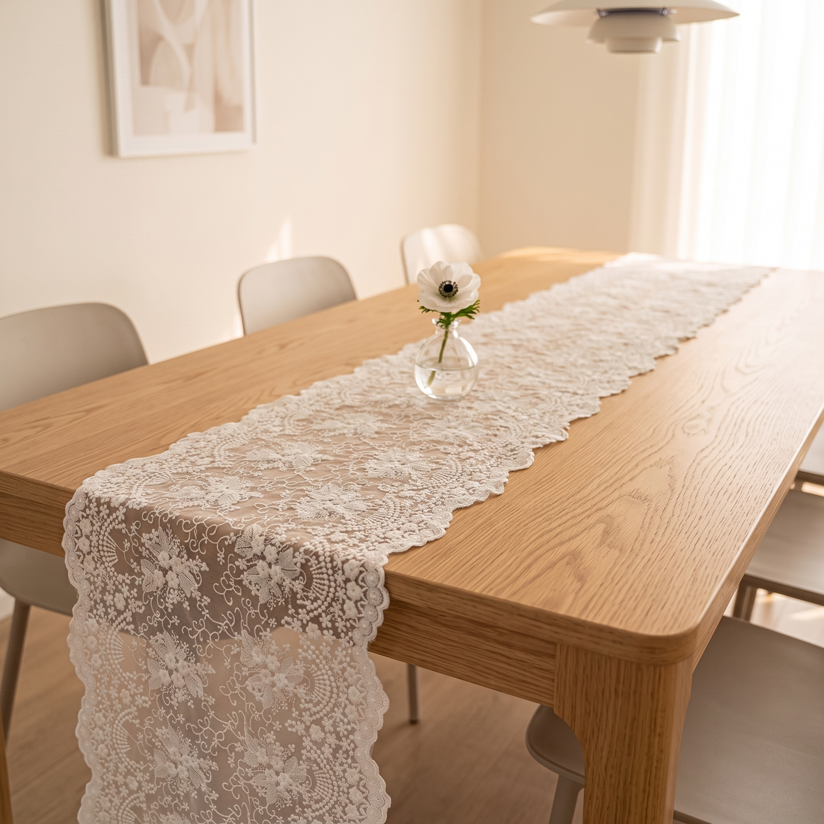 Lace Table Runner in White – draped along an oak dining table with a single flower vase