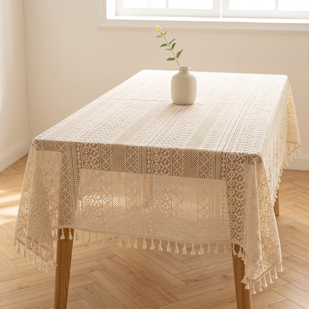 Lace Tablecloth with Tassels in Cream – draped over a wooden table with a small vase and stem