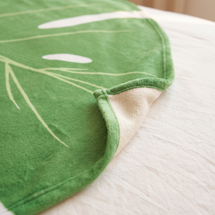 Leaf Blanket – Leaf-Shaped Flannel Throw in Green – Monstera – close-up of the curled edge showing the cream fleece underside
