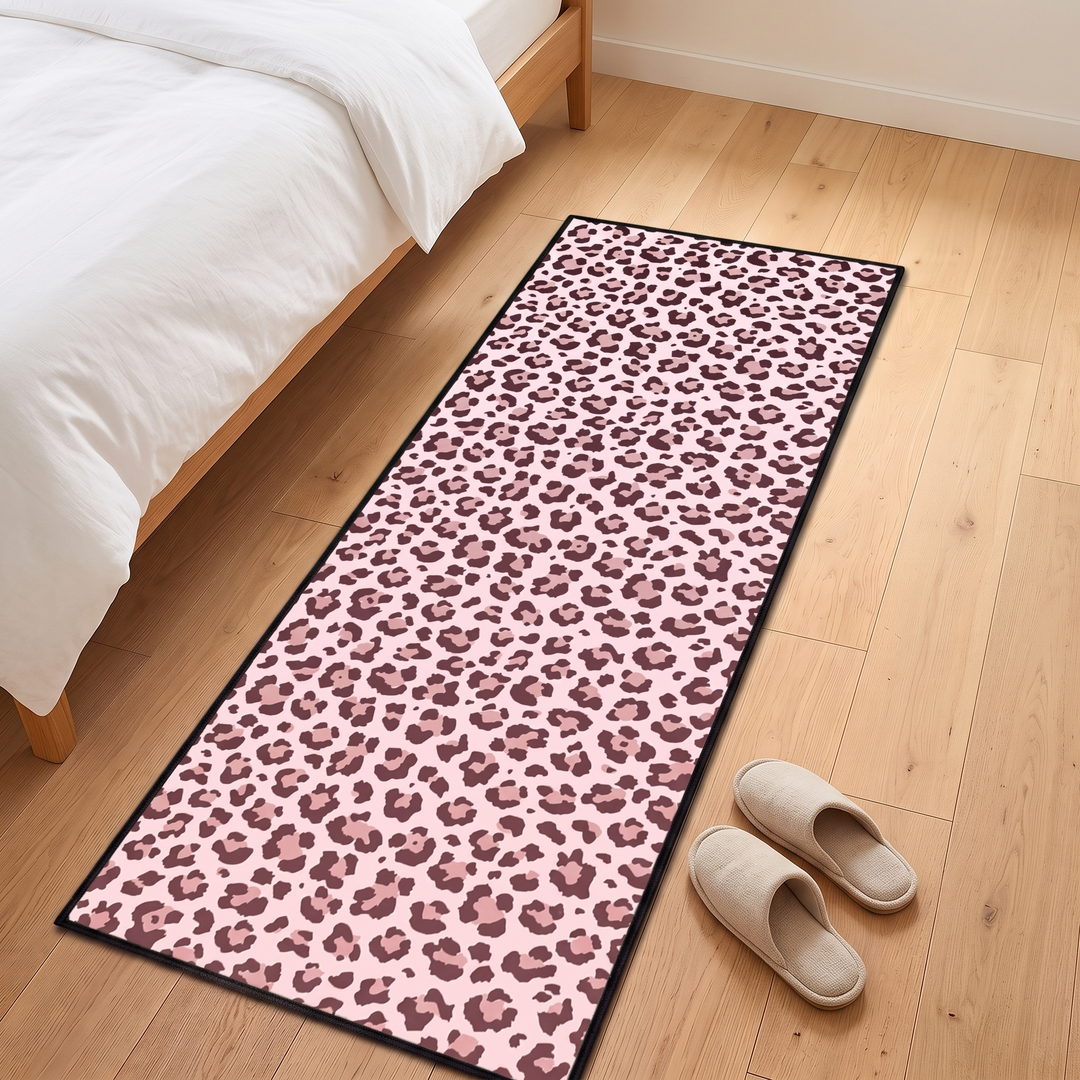 Leopard Print Runner Rug – Washable in Pink – on a wood bedroom floor beside a bed with slippers