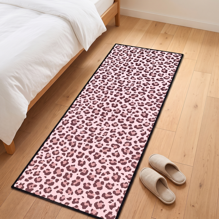 Leopard Print Runner Rug – Washable in Pink – on a wood bedroom floor beside a bed with slippers