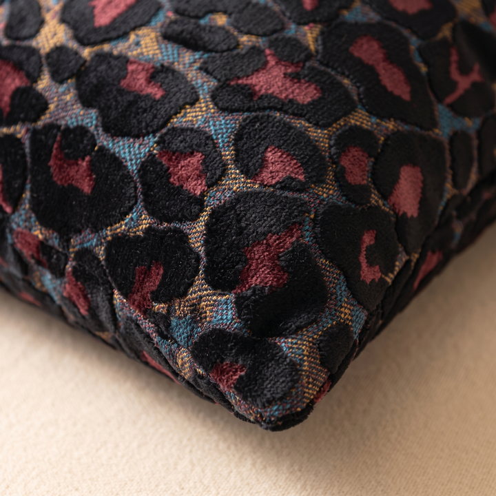 Leopard Print Velvet Pillow Cover in Black – close-up of a corner resting on a beige surface