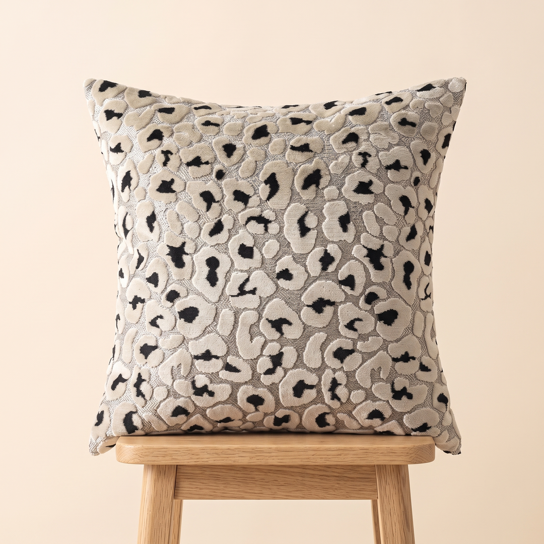 Leopard Print Velvet Pillow Cover in Black &amp; Beige – resting on top of a light wooden stool