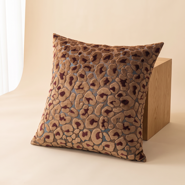 Leopard Print Velvet Pillow Cover in Camel – leaning against a wooden block beside a sheer curtain