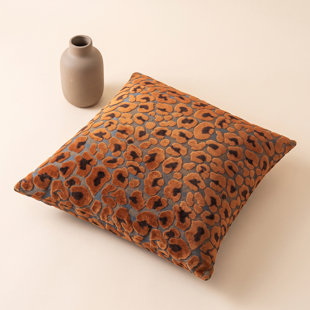 Leopard Print Velvet Pillow Cover in Orange – lying flat next to a small ceramic vase