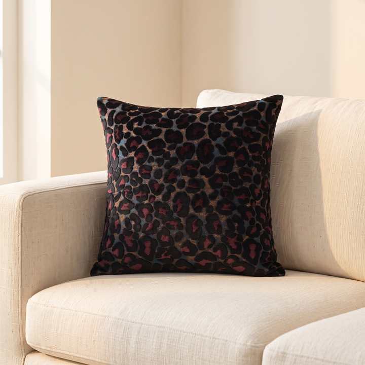 Leopard Print Velvet Pillow Cover in Black – propped in the corner of a cream sofa near a sunlit window