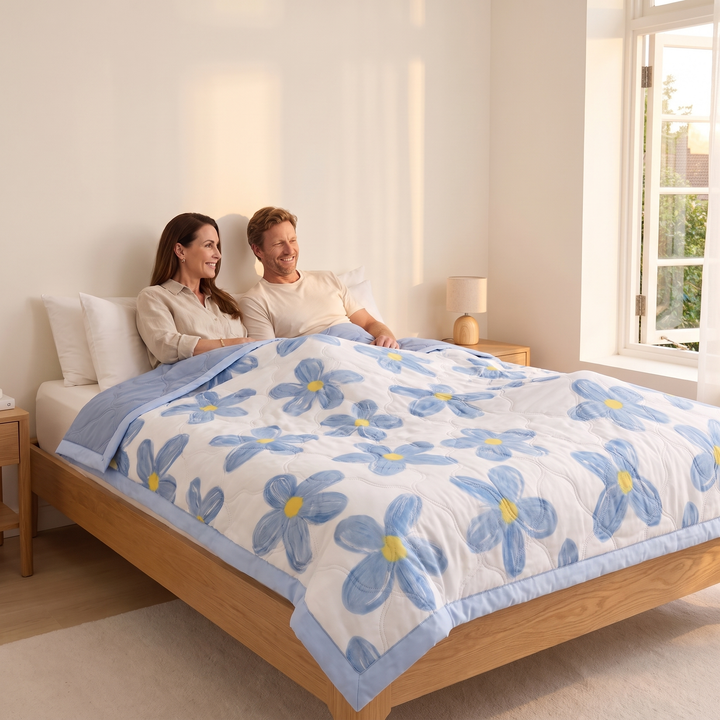 Lightweight Floral Quilt in Blue Floral – covering a couple sitting up in bed beside a sunny window