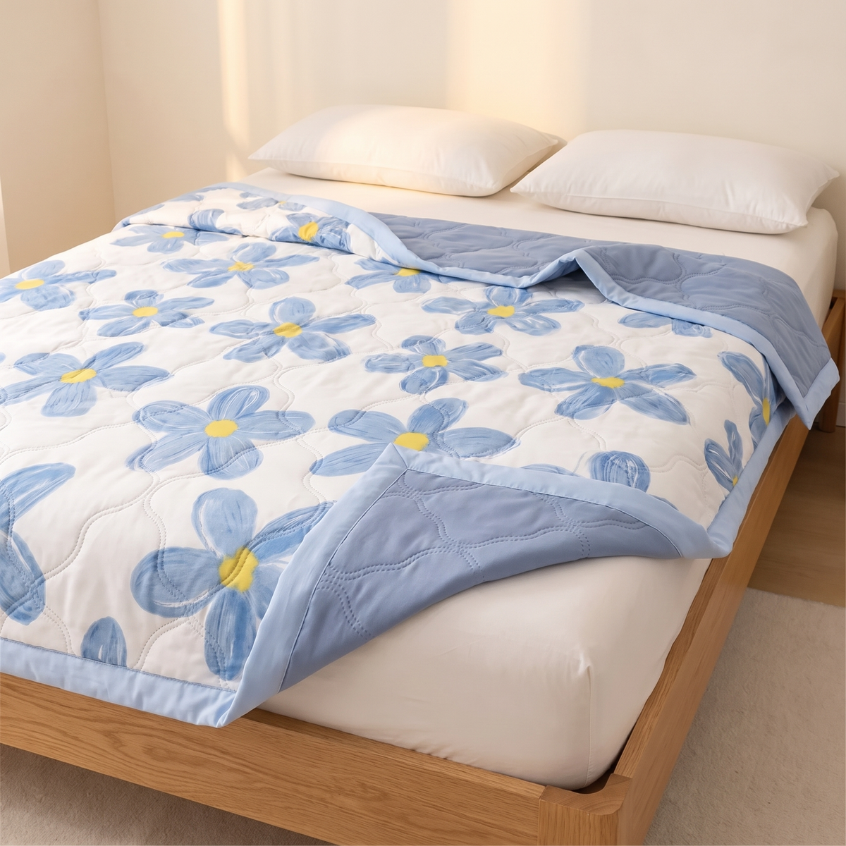 Lightweight Floral Quilt in Blue Floral – spread over a made bed with folded corner showing reverse