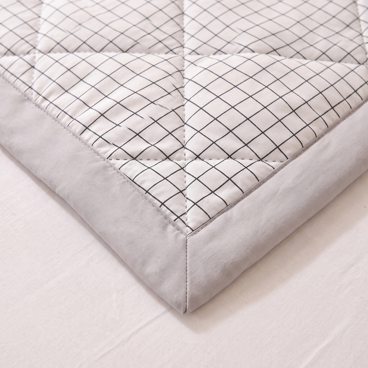 Lightweight Quilted Coverlet in White Grid – close-up of a corner with grey border and diamond quilting