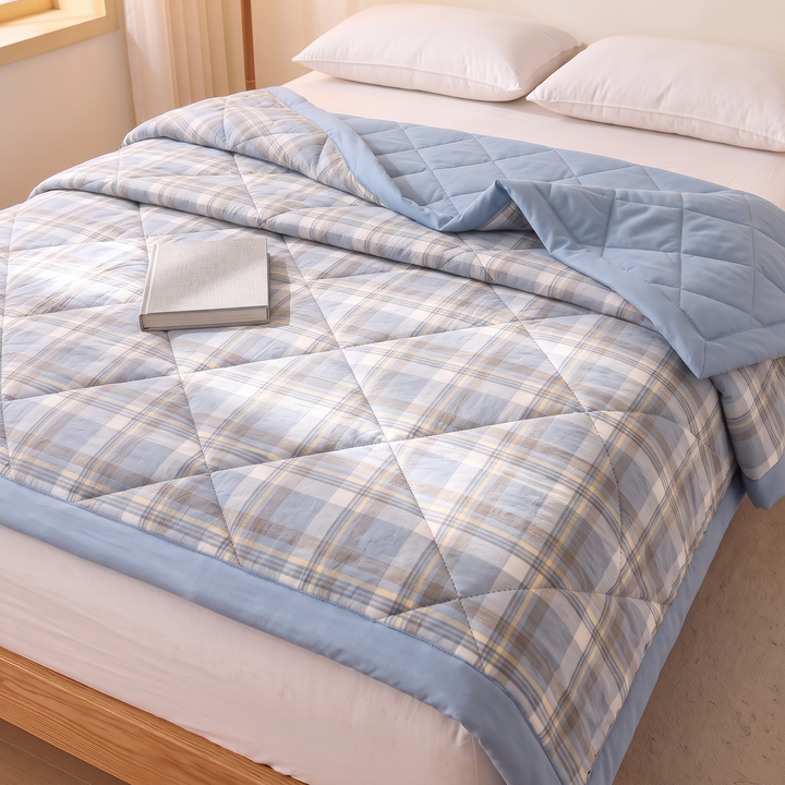 Lightweight Quilted Coverlet in Dusty Blue Plaid – high angle view with a closed book resting on top