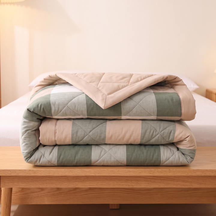 Lightweight Quilted Coverlet in Sage Buffalo Check – on a wooden bench in front of a bed