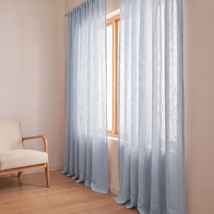Linen Curtain Panel – Light Filtering, Rod Pocket in Light Blue – angled view beside an armchair in a sunlit room
