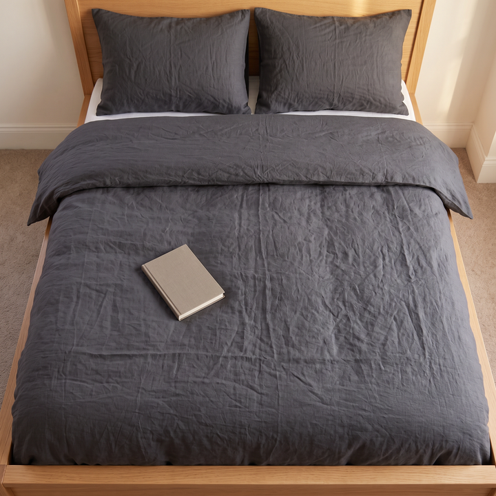 Linen Duvet Cover Set in Dark Charcoal – overhead view on oak bed frame with closed notebook