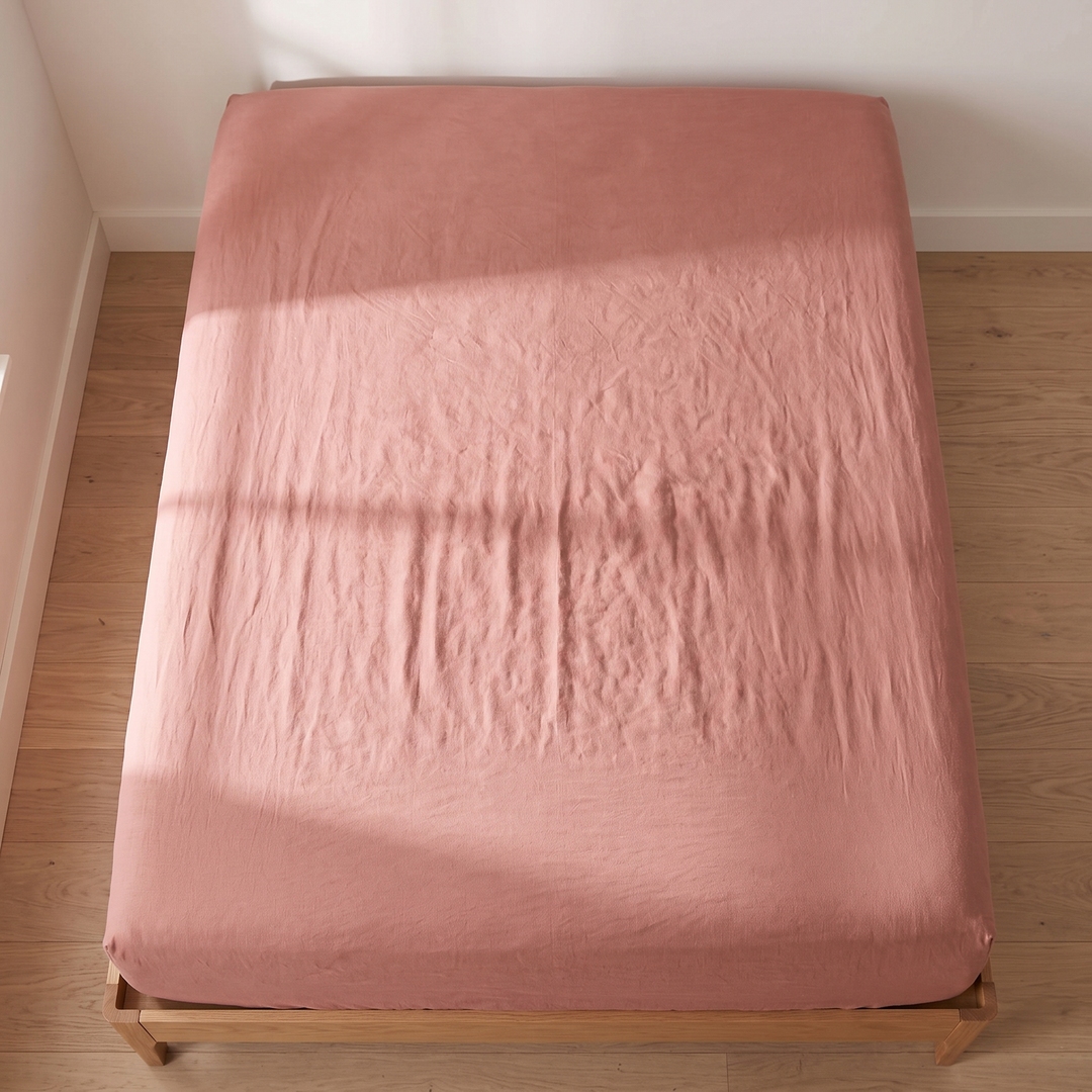 Linen Fitted Sheet – Deep Pocket in Terracotta – top-down view with window shadow falling across the mattress