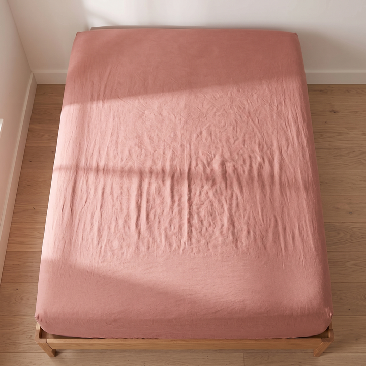 Linen Fitted Sheet – Deep Pocket in Terracotta – top-down view with window shadow falling across the mattress