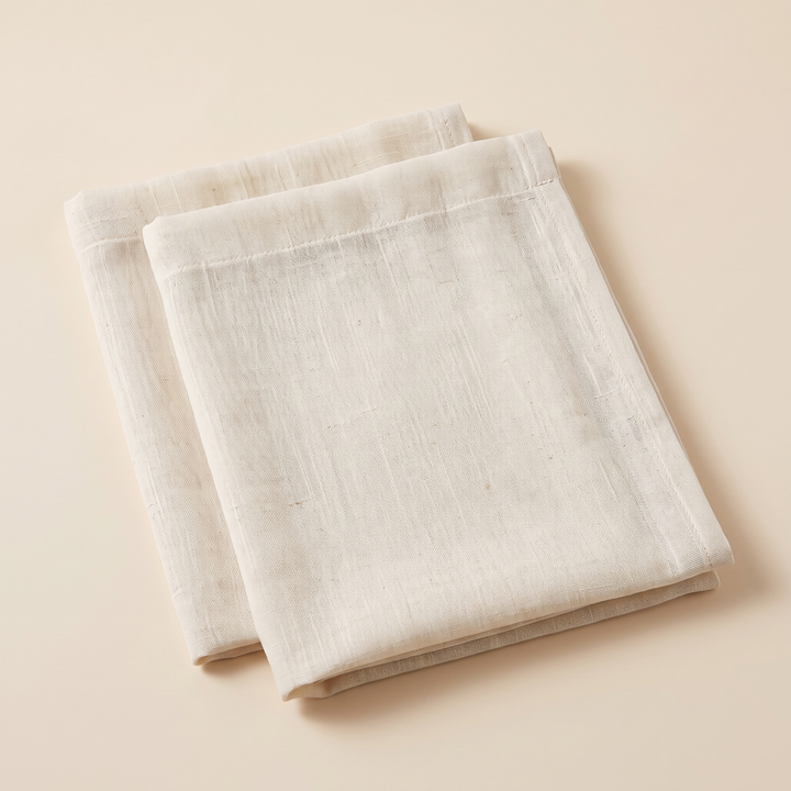 Cafe Curtains – Linen Look, Rod Pocket Top in Cream – two folded panels stacked on a plain peach background