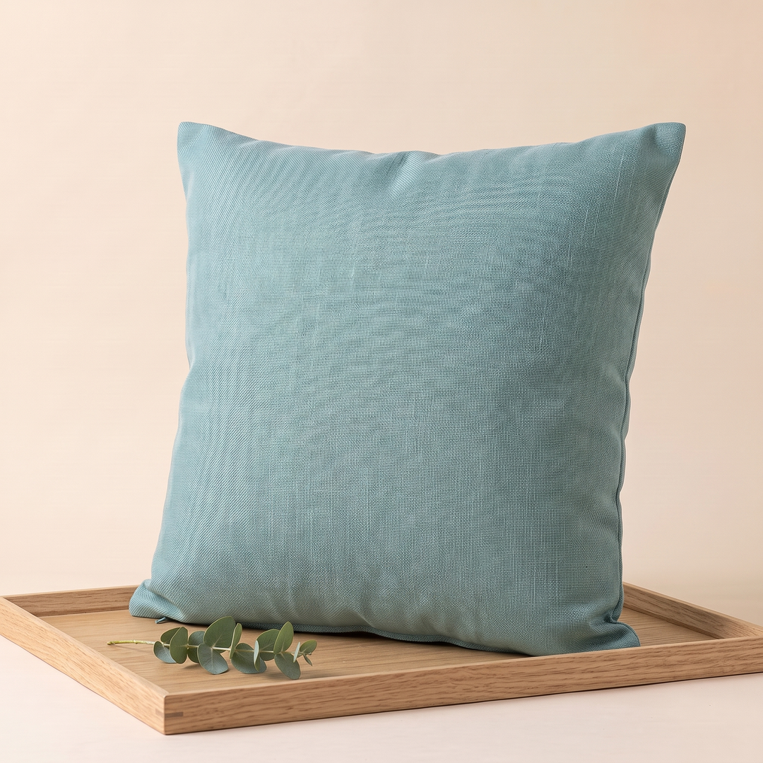 Linen-Look Pillow Cover in Aqua – upright on a wooden tray with a eucalyptus sprig