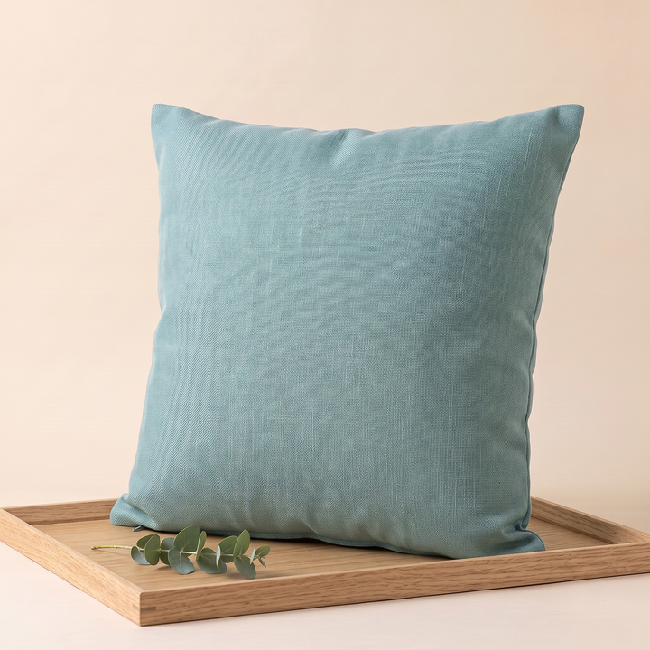 Linen-Look Pillow Cover in Aqua – upright on a wooden tray with a eucalyptus sprig