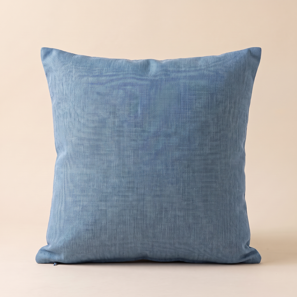 Linen-Look Pillow Cover in Blue – front view, stuffed and upright against a plain peach backdrop