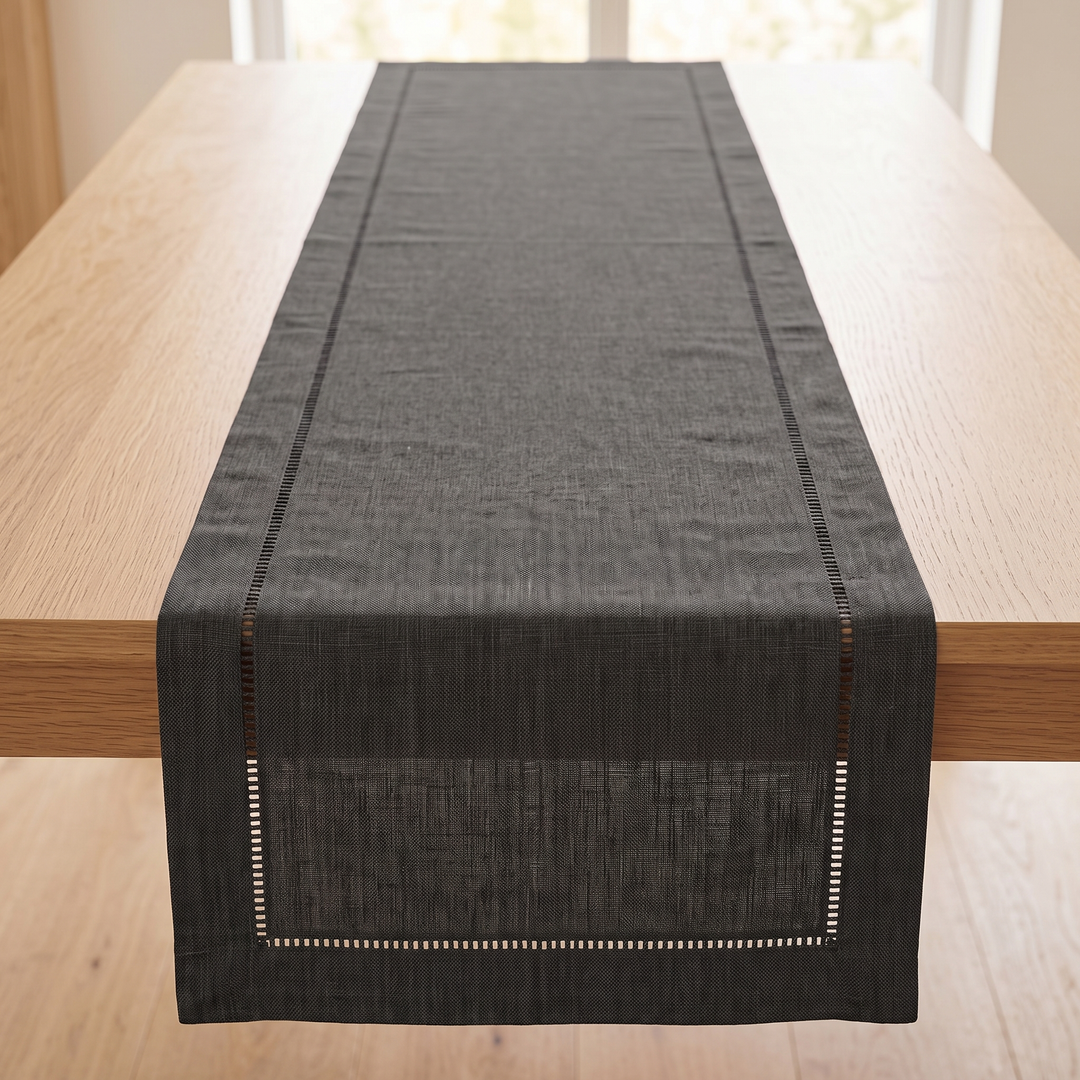Linen-Look Table Runner – Hemstitch Border in Dark Gray – stretching down an empty oak table, viewed from one end