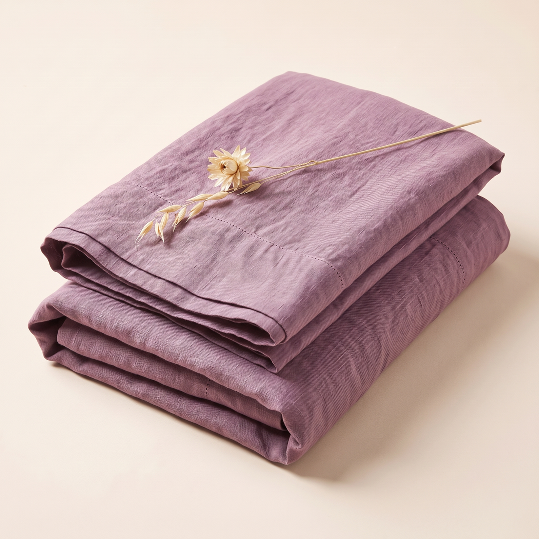Linen Pillowcases – Set of 2 in Mauve – folded stack with a dried flower stem laid on top