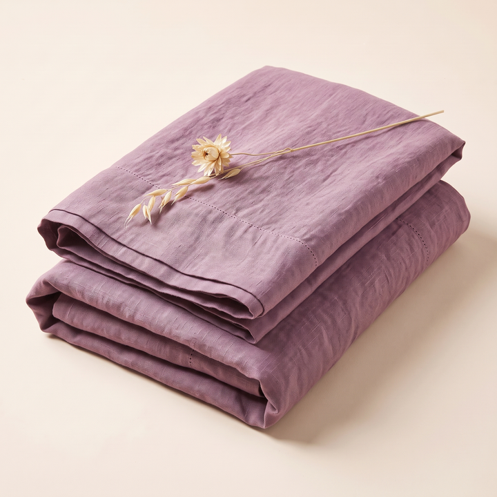 Linen Pillowcases – Set of 2 in Mauve – folded stack with a dried flower stem laid on top
