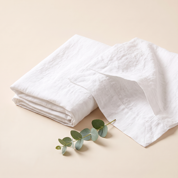 Linen Pillowcases – Set of 2 in White – folded stack with one open pillowcase beside a eucalyptus sprig
