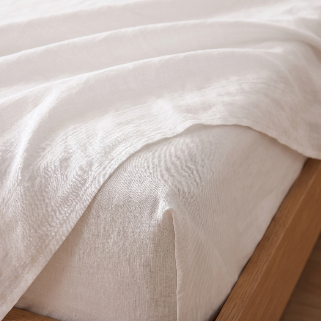Linen Sheet Set in White – close-up of fitted sheet corner beneath a rumpled top sheet