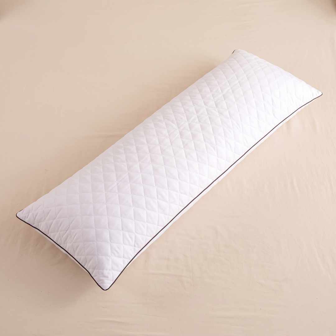 Long Body Pillow – Quilted in White – lying flat on a cream sheet, seen from above at an angle