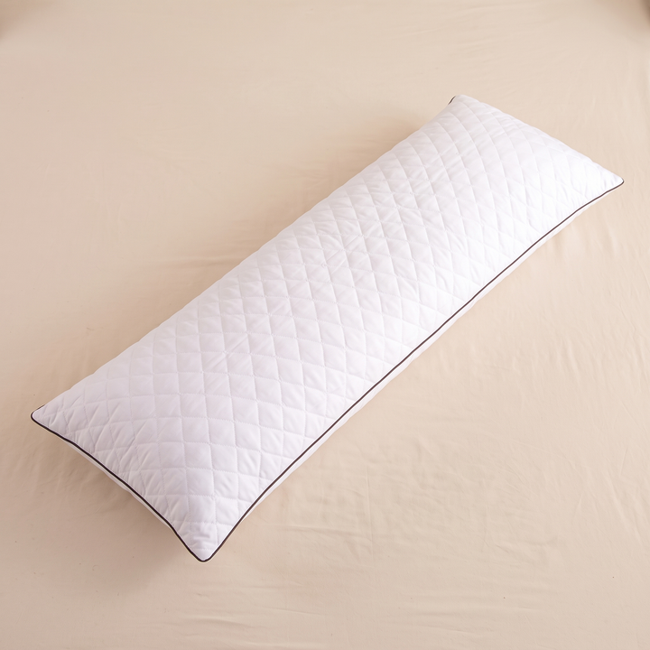 Long Body Pillow – Quilted in White – lying flat on a cream sheet, seen from above at an angle