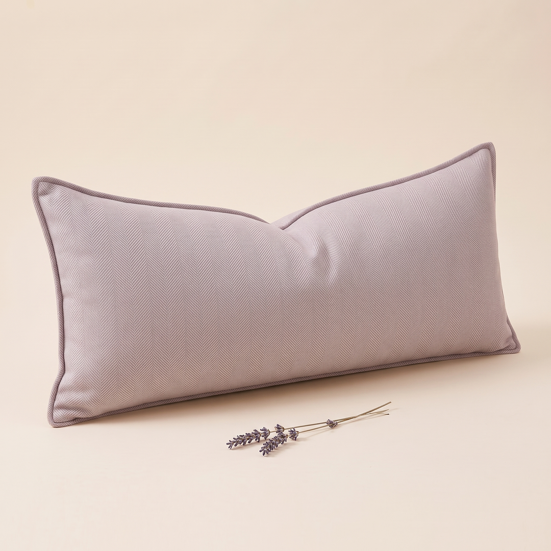Long Lumbar Pillow Cover in Lilac – leaning at an angle with a lavender sprig lying in front