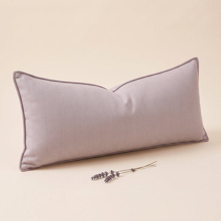 Long Lumbar Pillow Cover in Lilac – leaning at an angle with a lavender sprig lying in front