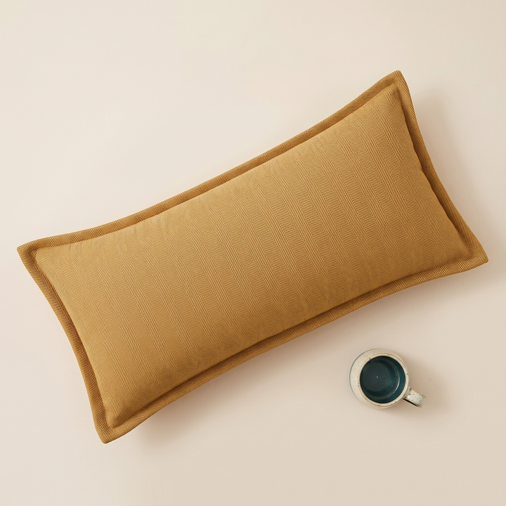 Long Lumbar Pillow Cover in Mustard – overhead with a teal-lined speckled mug at lower right