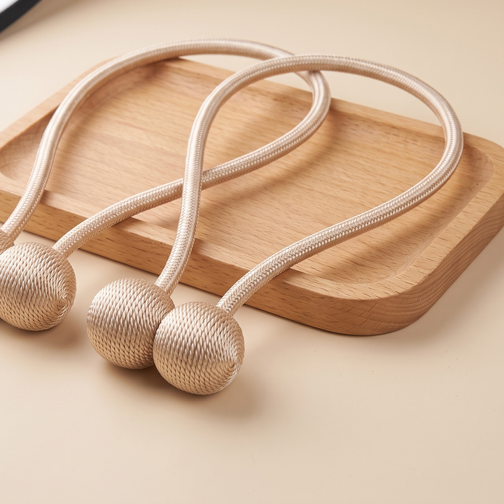 Magnetic Curtain Tiebacks – Set of 2 in Gold – resting across a rounded light wood tray