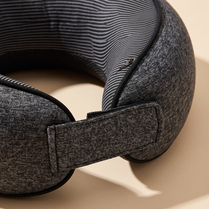 Memory Foam Neck Pillow for Travel in Dark Gray – close-up of the strap and striped inner lining on a beige surface