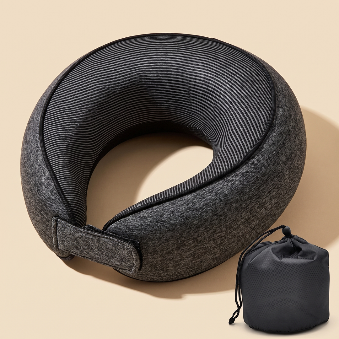 Memory Foam Neck Pillow for Travel in Dark Gray – with strap fastened beside a drawstring storage pouch on beige