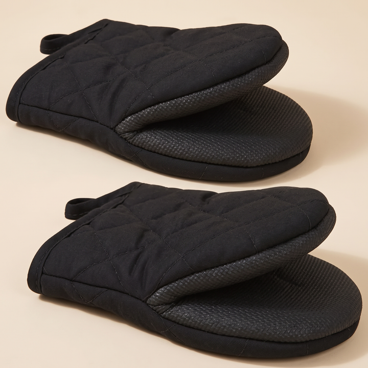 Mini Oven Mitts – Quilted, Pair in Black – two mitts stacked on a plain beige background, grip sides visible