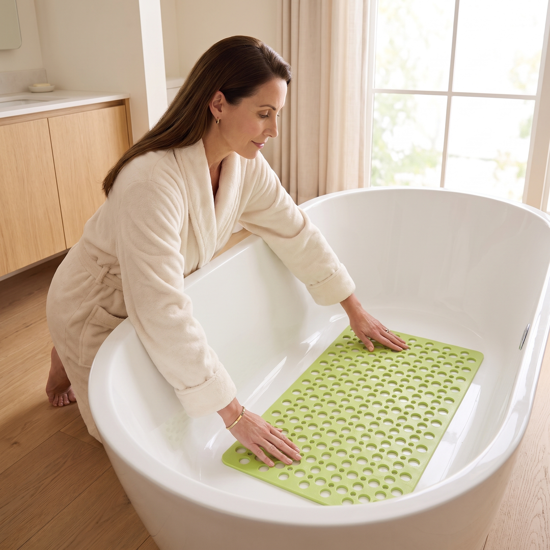 Non-Slip Shower Mat with Suction Cups in Lime Green – woman in a robe pressing it down in a freestanding tub