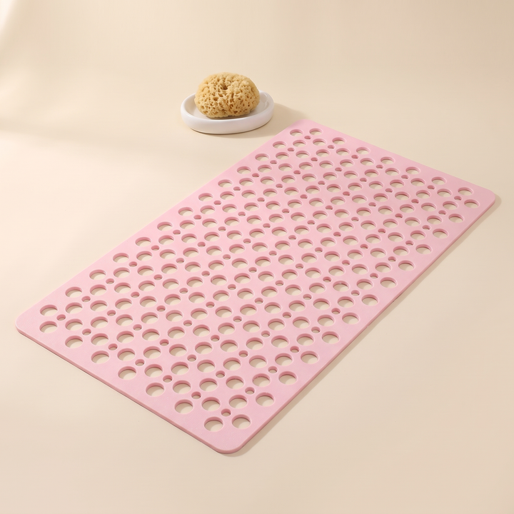 Non-Slip Shower Mat with Suction Cups in Light Pink – beside a natural sponge on a small white dish