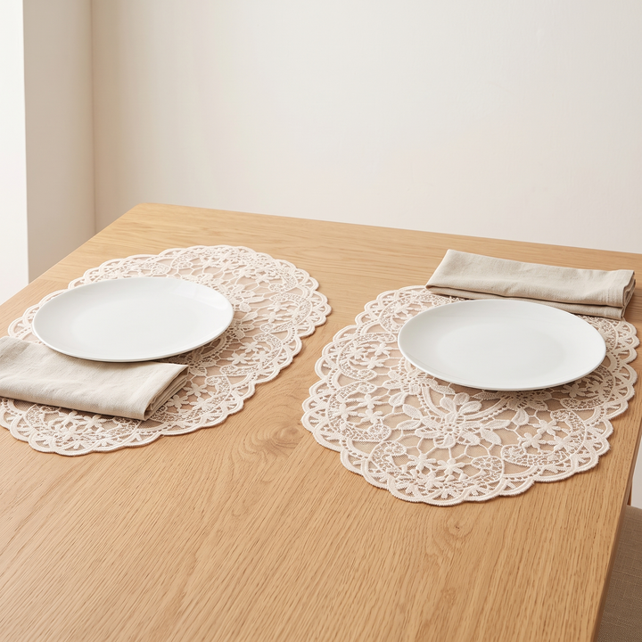 Oval Lace Placemats – Embroidered in Cream – under white plates on a light oak table