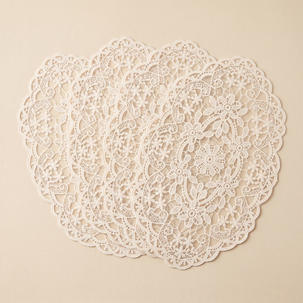 Oval Lace Placemats – Embroidered in Cream – four mats fanned on an oat backdrop