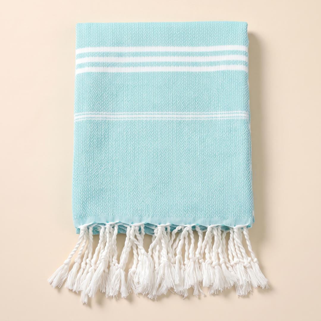 Oversized Beach Towel with Tassels in Turquoise – overhead view of stripe bands above twisted hanging tassels