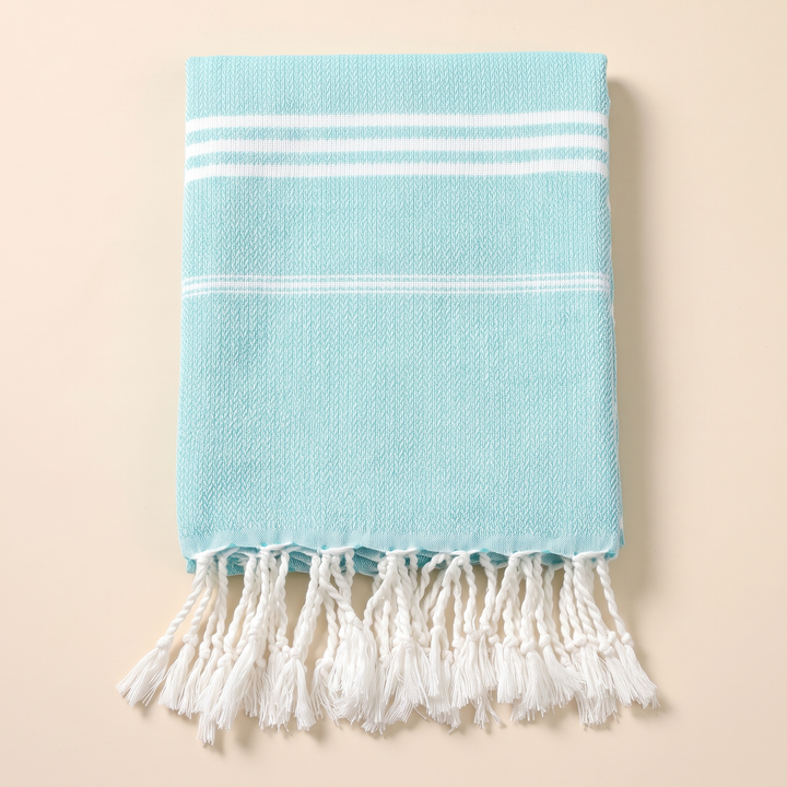 Oversized Beach Towel with Tassels in Turquoise – overhead view of stripe bands above twisted hanging tassels