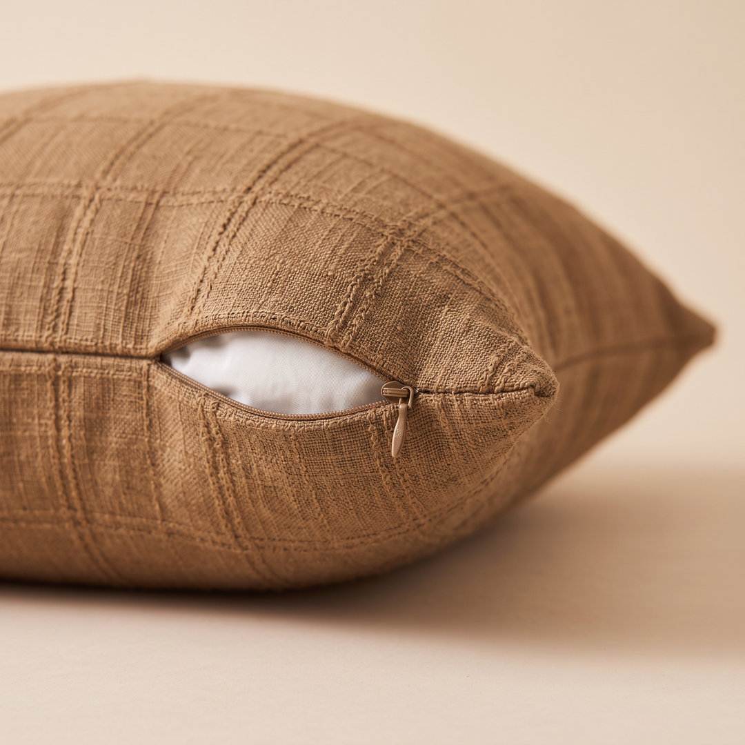 Plaid Pillow Cover – Textured Grid Check in Brown – close-up of the side zipper partly open, resting on a cream surface