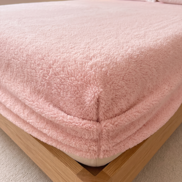 Plush Fleece Fitted Sheet – Deep Pocket in Pink – close-up of a stitched corner fitted on a mattress with a light wood bed frame