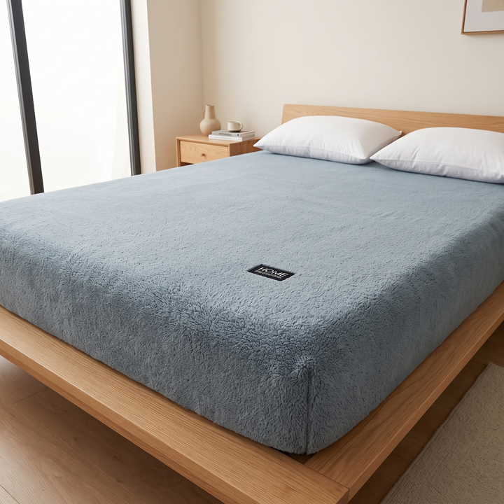 Plush Fleece Fitted Sheet – Deep Pocket in Dusty Blue – mattress side with small black label on oak platform bed