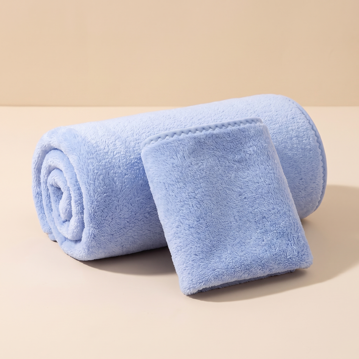 Plush Bath Towel Set – 2 Piece in Light Blue – large towel rolled up with small towel leaning against it on beige surface