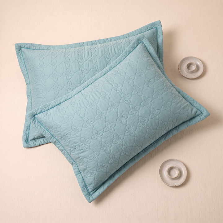 Quilted Cotton Pillow Shams – Set of 2 in Aqua – overhead view of overlapping shams beside two small ceramic dishes