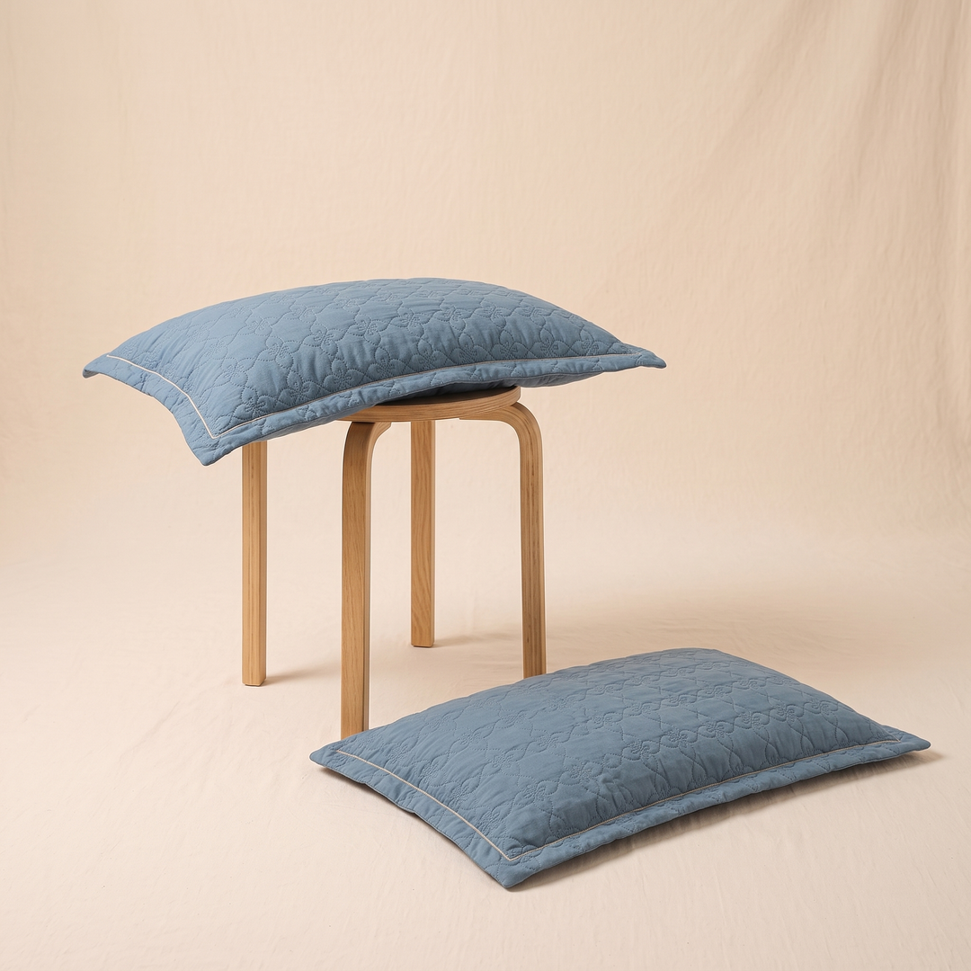 Quilted Cotton Pillow Shams – Set of 2 in Denim Blue – one sham on a wooden stool, another on the floor