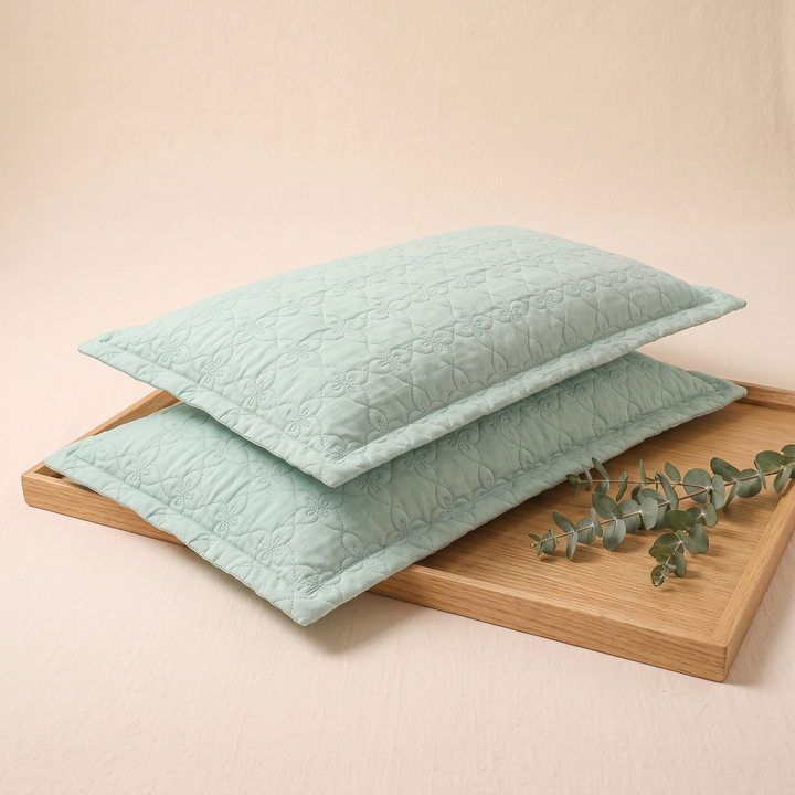 Quilted Cotton Pillow Shams – Set of 2 in Mint Green – on a wooden tray beside a eucalyptus sprig